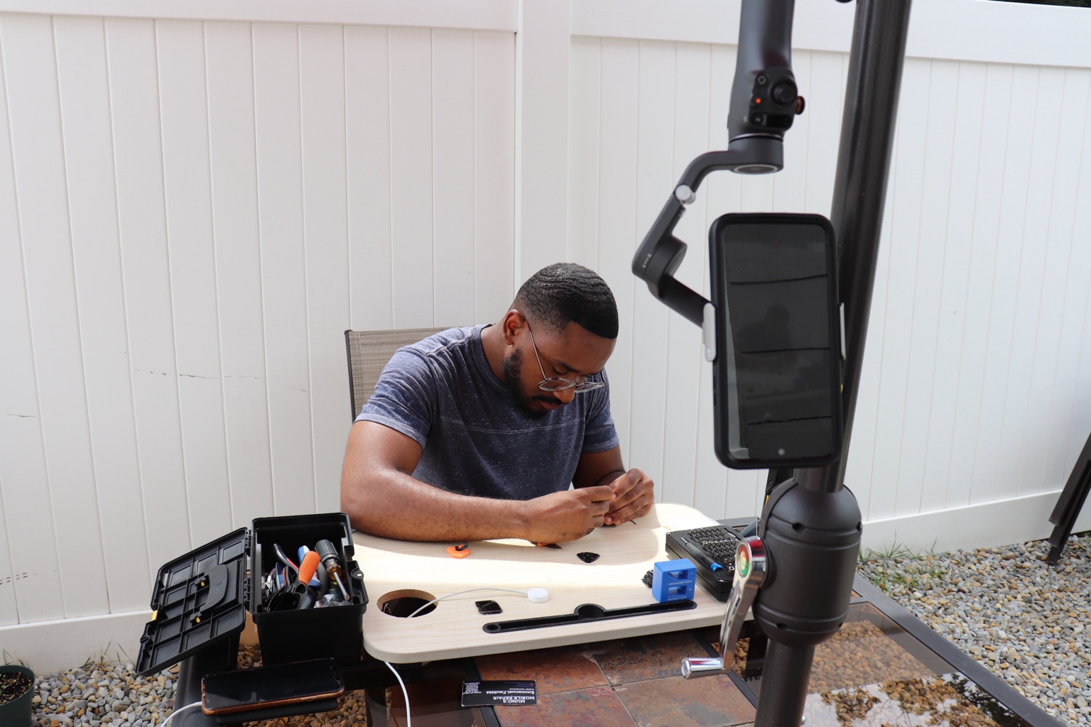 Emmanuel working on an electronics repair at his portable workbench